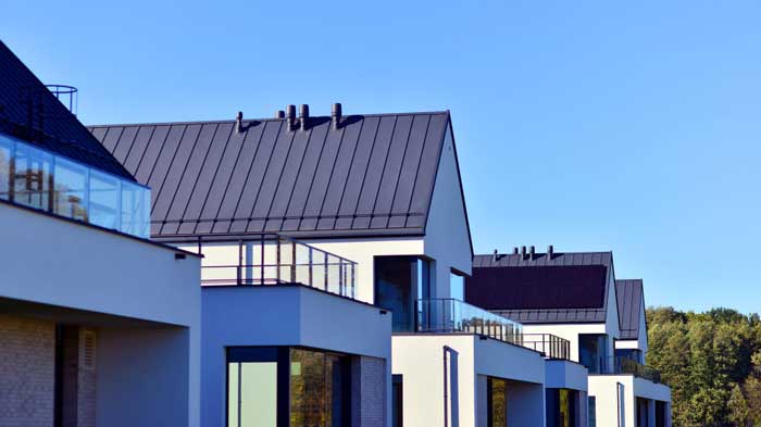 Row of modern residential buildings with standing seam metal roofing, highlighting contemporary design, durability, and reliable Roof Repair Fellsmere, FL services.