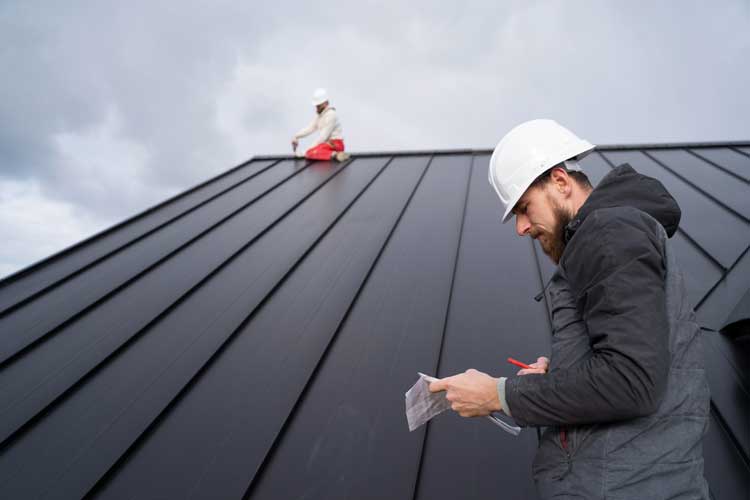 Roofing professionals inspecting and repairing a standing seam metal roof on a residential property, demonstrating quality workmanship and dependable Roof Repair Gifford, FL services.