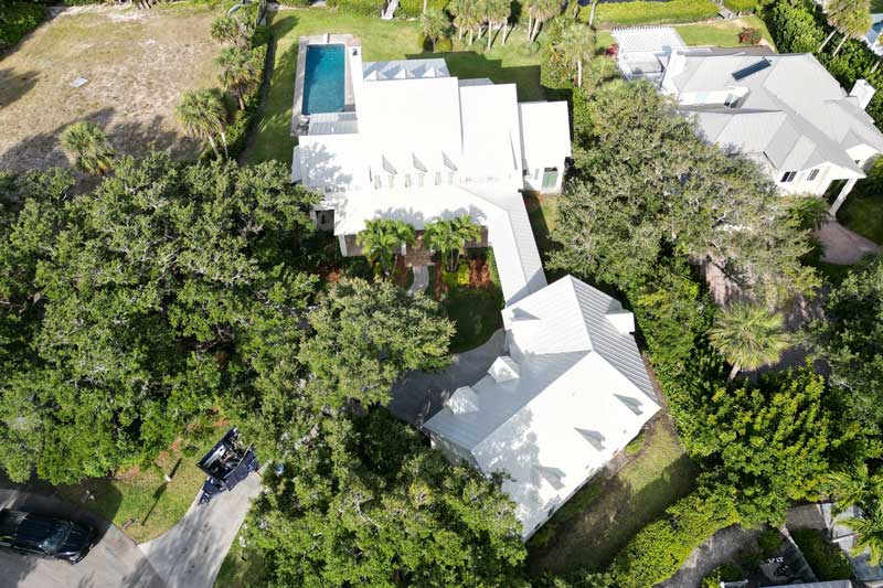 Aerial view of coastal residential homes with metal roofs near the ocean, showcasing premium installation, durability, and professional Roof Repair Indian River County, FL services.