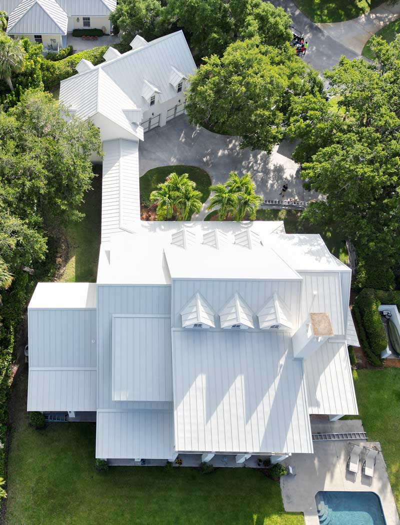 Top-down aerial view of luxury residential homes with modern metal roofing and central pool courtyard, showcasing premium craftsmanship and trusted Roof Repair Indian River County, FL services.